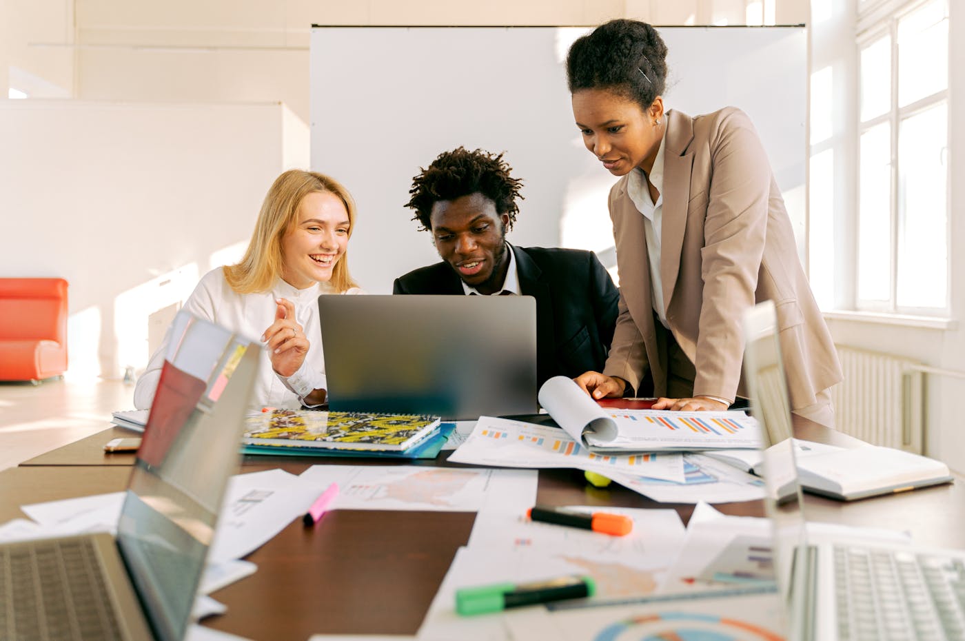 Professional team collaborating around laptops in a modern office