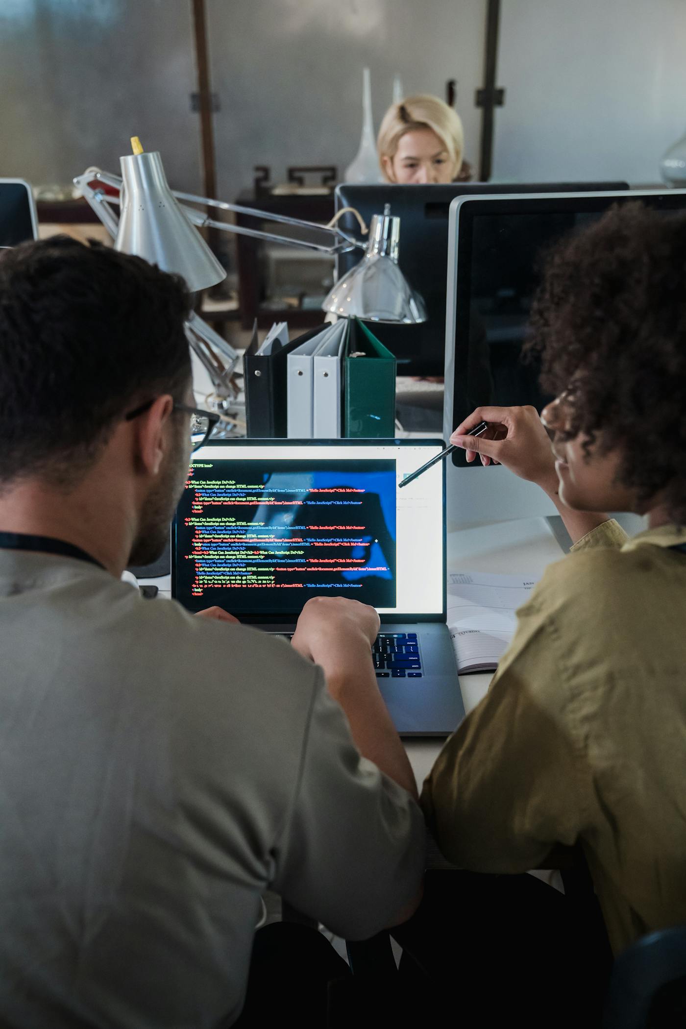 Software professionals discussing development work on a laptop